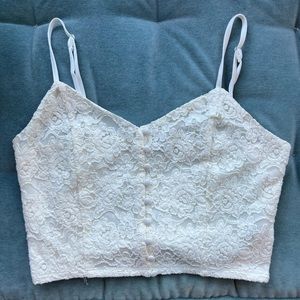 Lightly worn crop top, lace pattern, adjustable straps, buttons down the front.